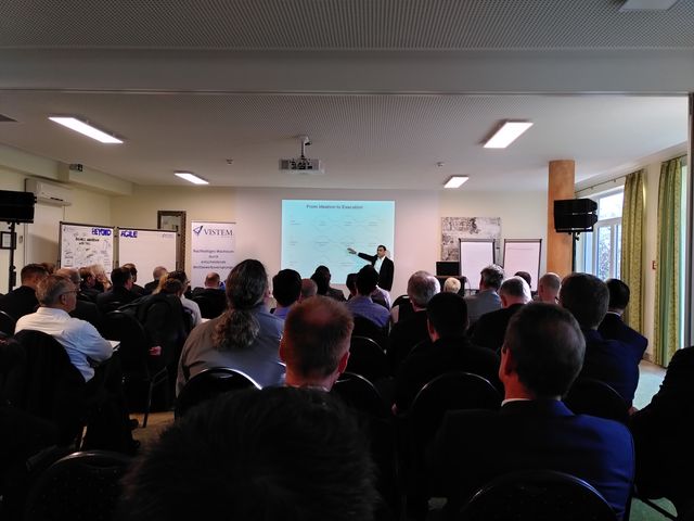 Referent vor der Leinwand im vollen Saal
